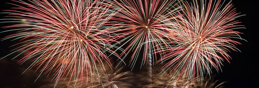 Photo d'un feu d'artifice automatique tiré au dessus d'une ville avec trois grosses explosions